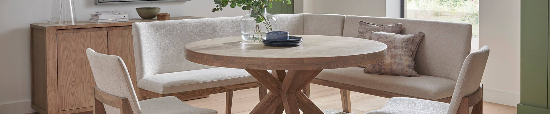 A stylish dining room setup with a modern dining table, chairs, dining bench with back, and a sideboard for storage.