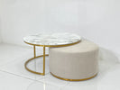 Round marble coffee table with gold frame and matching ottoman on a white floor.