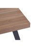 Detailed shot of the wooden surface and one black metal leg of the Oakland Coffee Table.

