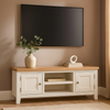 TV mounted on a wall above a wooden TV stand with decor items.
